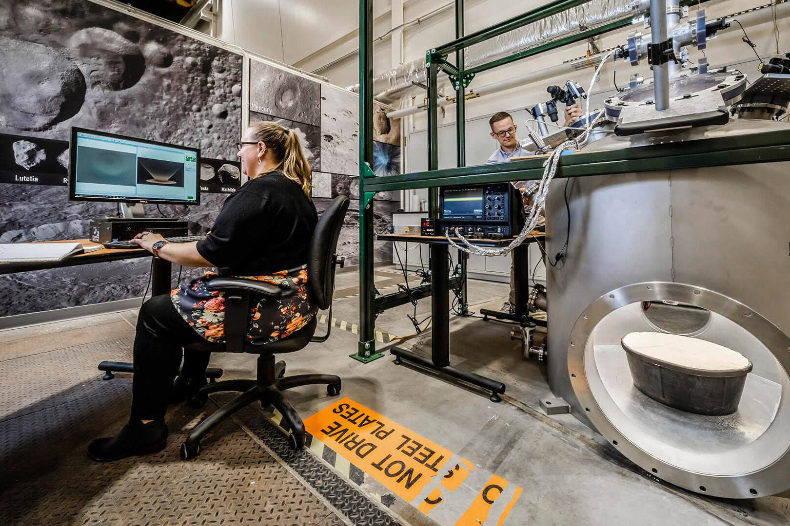 Scientist working on a computer with lab in background