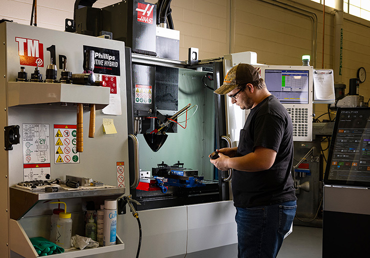 Hunter Turco, a senior mechanical fabrication technician, adjusts parts on a 3D printer in one of APL’s fabrication facilities.