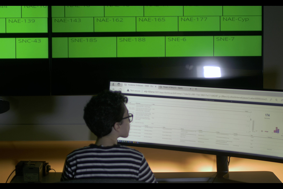 An industrial security professional looks at a computer screen to monitor alerts provided by BAS/CS.