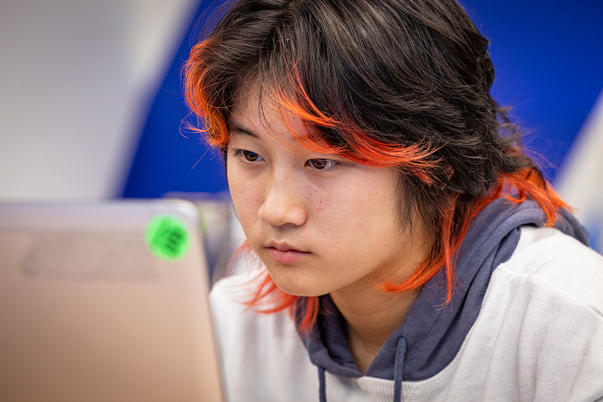 STEM Academy student looks at a laptop