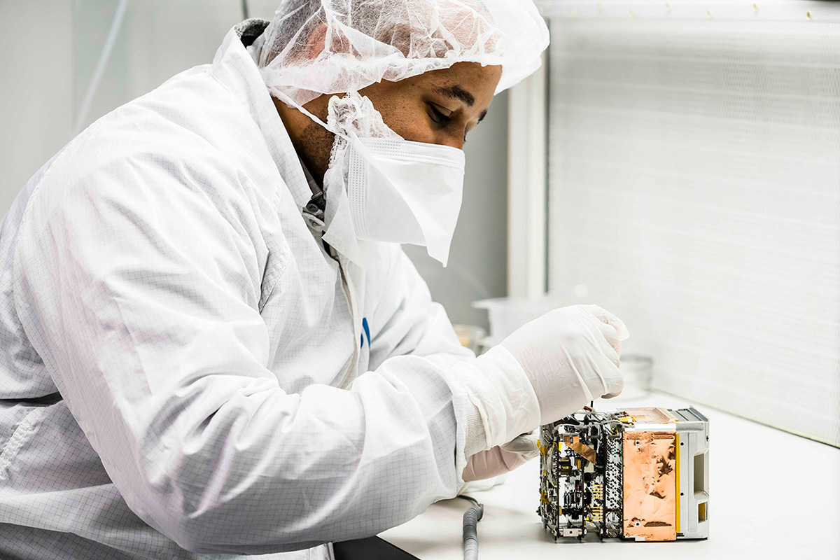 APL computer engineer Clifton Lomax inspects the Relativistic Electron Atmospheric Loss (REAL) instrument. (Credit: Johns Hopkins APL)