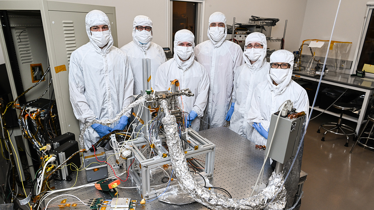 Members of the Ion Trap Mass Spectrometer team inspect their device, part of the Dragonfly Mass Spectrmeter (DraMS) instrument package, at NASA’s Goddard Space Flight Center.