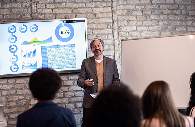 Businessman delivers a presentation to colleagues (Credit: Adobe Stock)