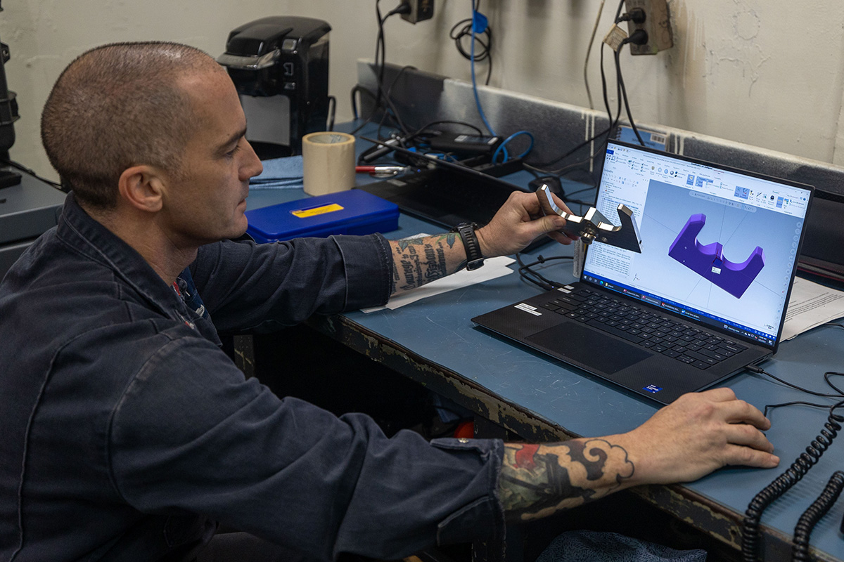 Machinery Repairman 1st Class Cory Hover demonstrates the software used to design the sprayer plate