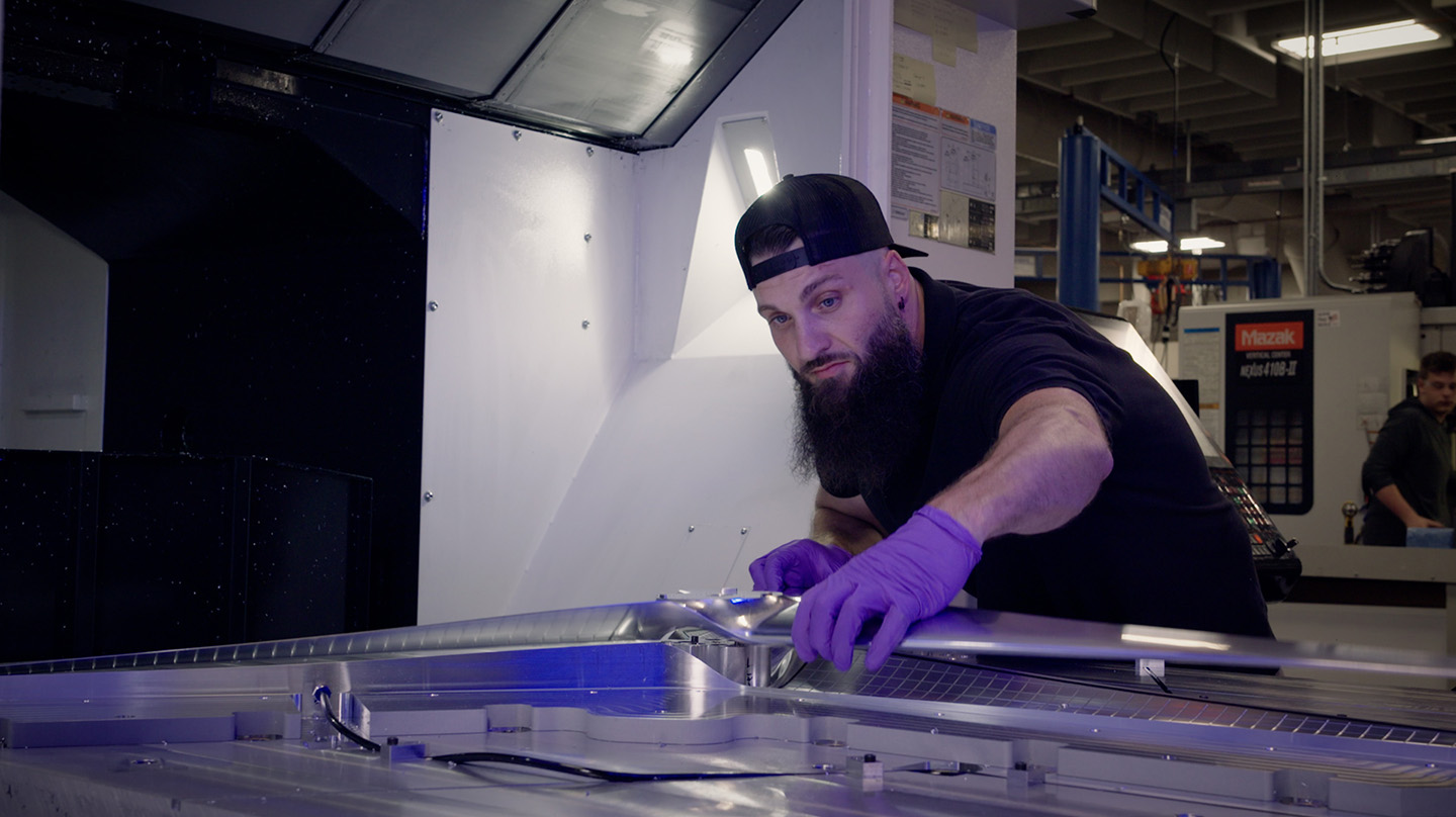 Experimental machinist Cory Pennington examines a freshly milled, full-scale Dragonfly rotor
