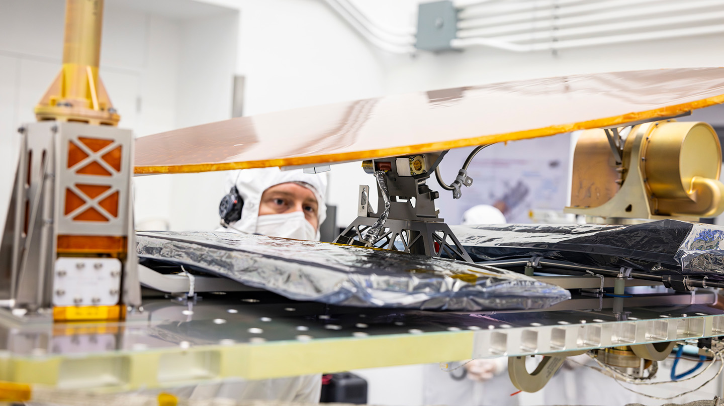 APL engineer Jackson Banbury inspects the motorized arm that attaches Dragonfly’s high-gain antenna to the spacecraft body.
