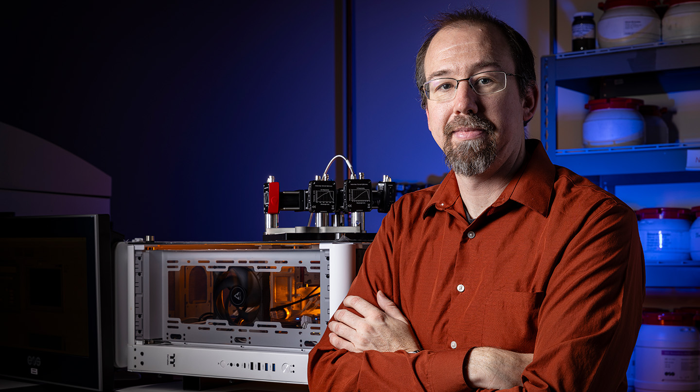 Steve Storck poses in front of the Spectrally Augmented Thermal Understanding Reducing Nonconformance (SATURN) sensor