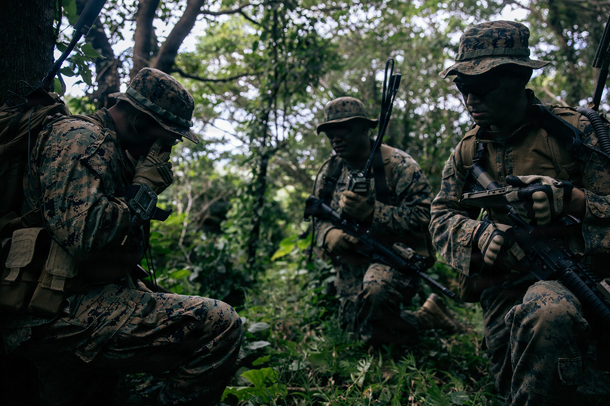 U.S. Marines with 7th Communication Battalion, III Marine Expeditionary Force Information Group, report back to the combat operations center during a jungle training event at Camp Hansen, Okinawa, Japan, Feb. 4, 2026. The training focused on small-unit tactics, sustainment, camouflage and survivability skills to enhance operational readiness in austere environments. (U.S. Marine Corps photo by Cpl. Meshaq Hylton)