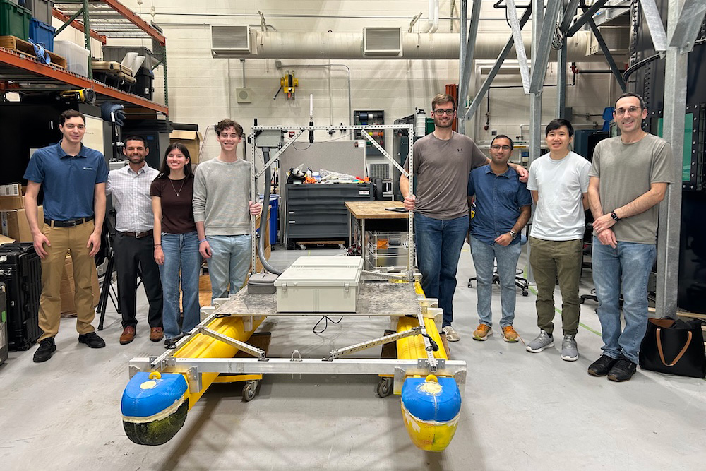 APL staff and WSE students pose with an operational prototype of an inexpensive, modular, and lightweight USV