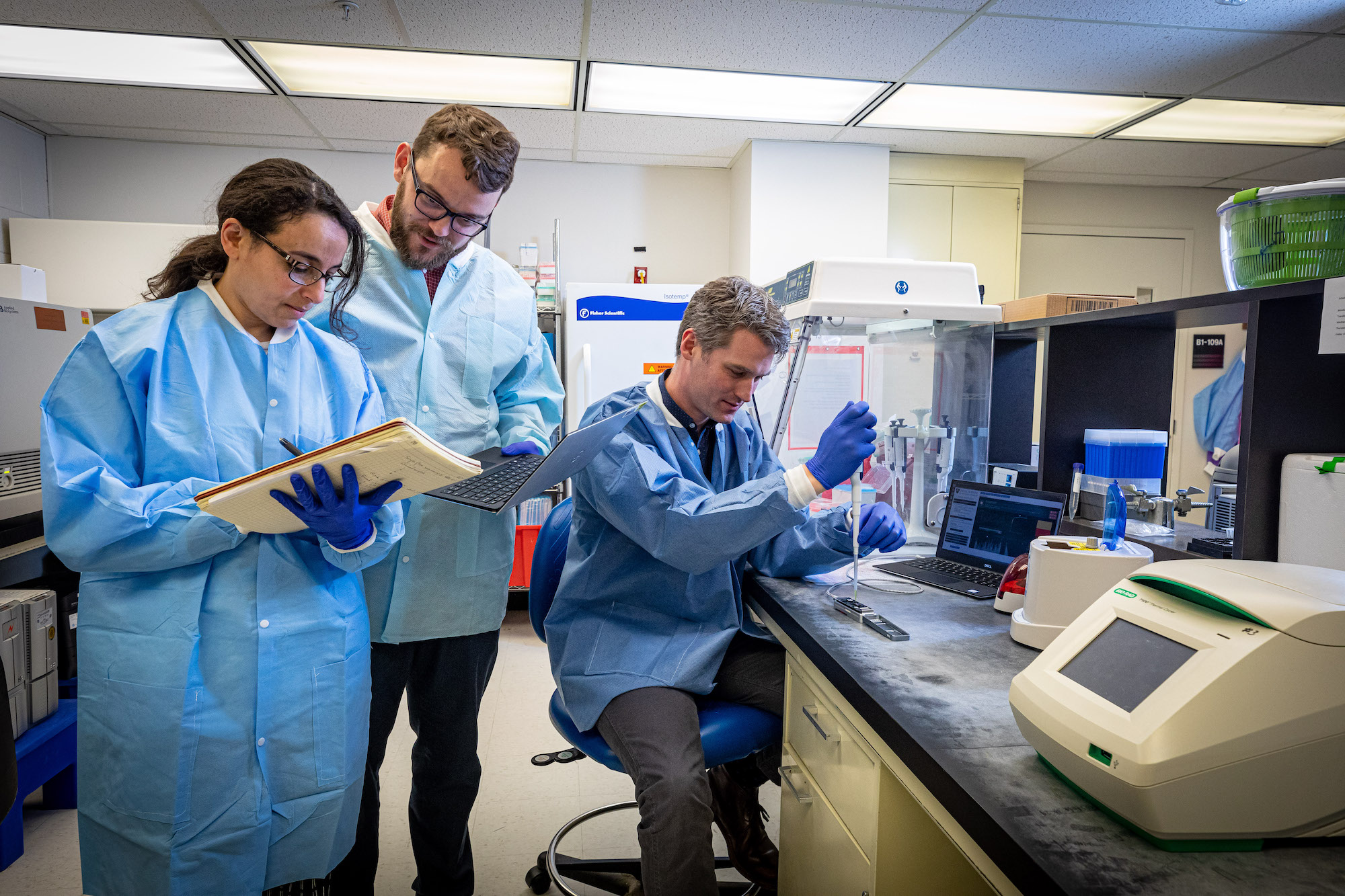 Heba Mostafa, Assistant Professor of Pathology at Johns Hopkins Medicine, joins APL biologists Tom Mehoke, left, and Peter Thielen as the team initiates a sequencing of the genome of the SARS-CoV-2 virus, which causes COVID-19.