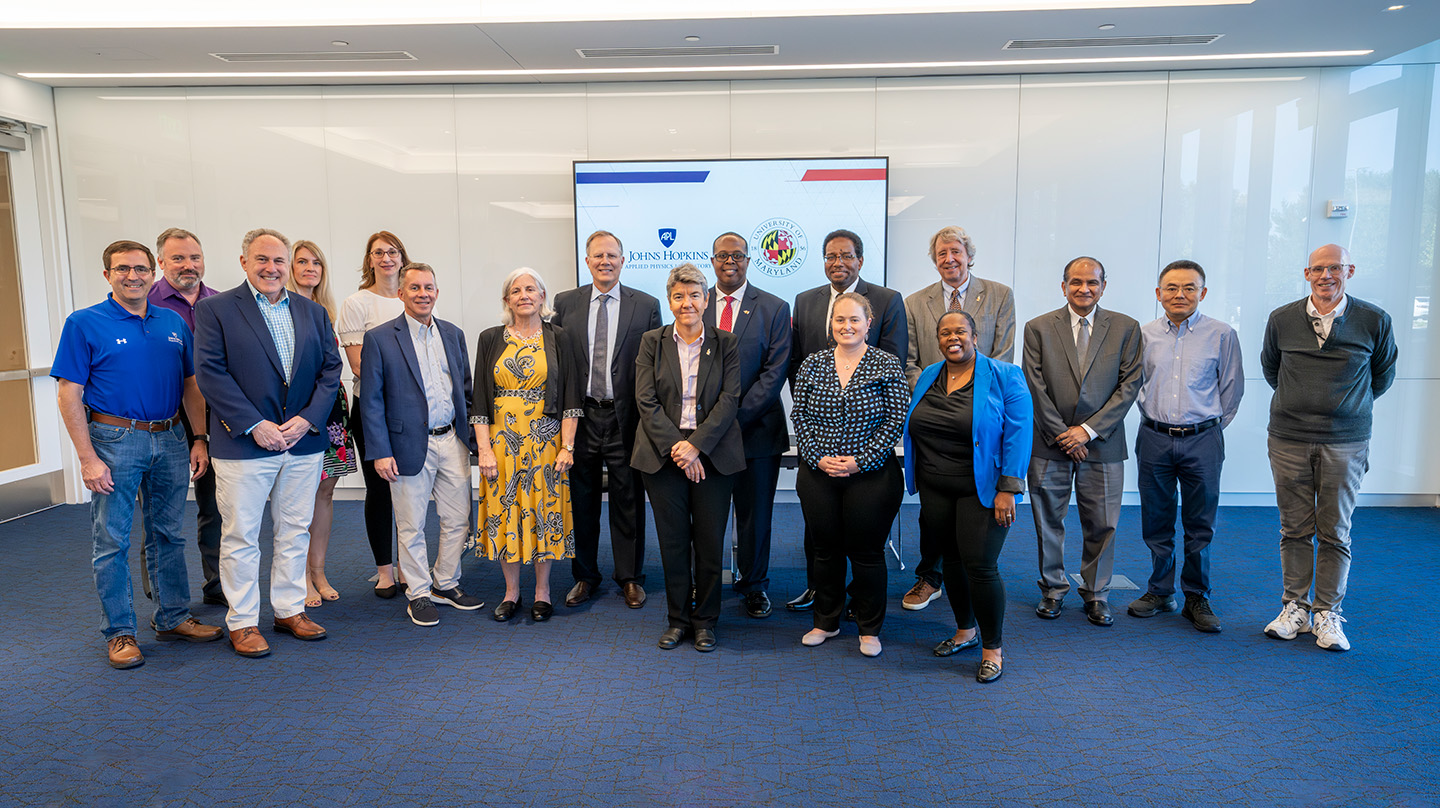 Representatives from Johns Hopkins APL and University of Maryland attend a signing of the MOU.