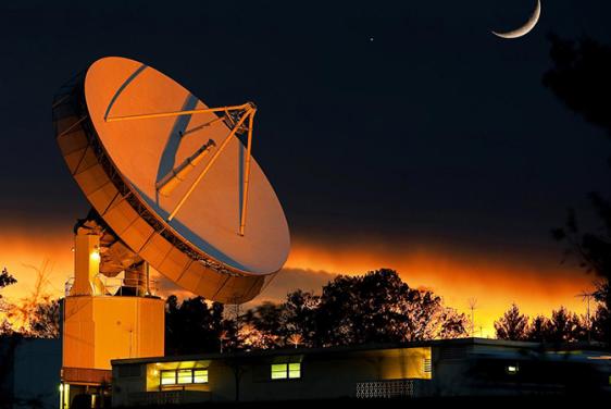 Johns Hopkins APL's 60-foot dish antenna illuminated at night