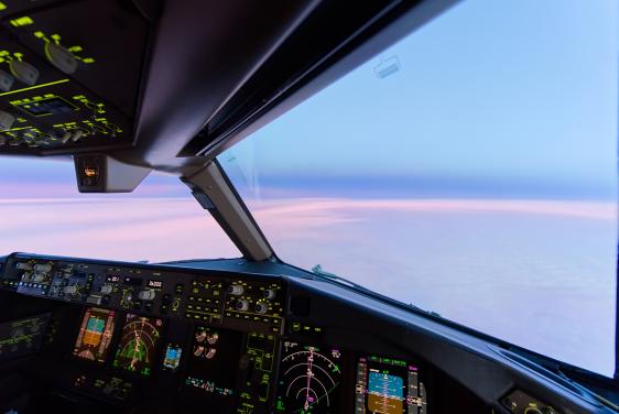 View of twilight from cockpit of a plane, with instrument panel in foreground (Credit: Bigstock)